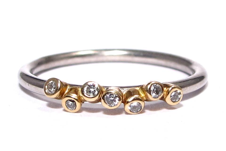 This edgy yet gorgeous ring features 7 diamonds bezel set in yellow gold with a round wire palladium band.