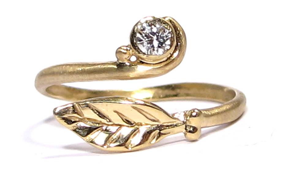 This leafy organic ring features a 3mm diamond bezel set in yellow gold.