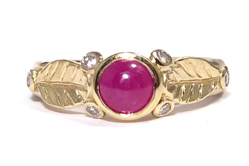 This organic leafy ring features a cabochon ruby and 6 white diamonds on the sides.