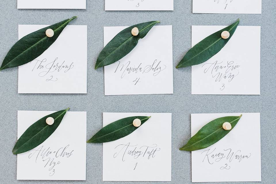 Escort cards hand lettered by Prairie Letter Shop.