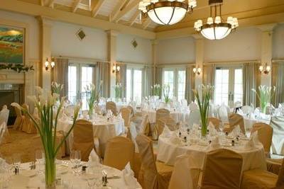 Simple and elegant reception table arrangemnt designed with long stem cream calla lilies in a clear glass cylinder vase.