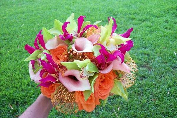 Stem style bouquet designed with pink mini callas, orange roses, green cymbidium orchid blooms.