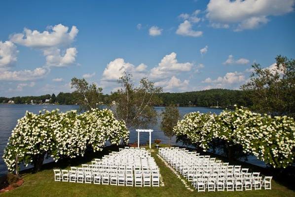 An outdoor ceremony site with white garden chairs.