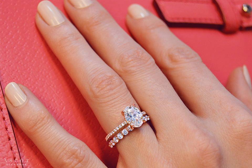 Custom oval cut diamond engagement ring and custom eternity diamond wedding band in rose gold
