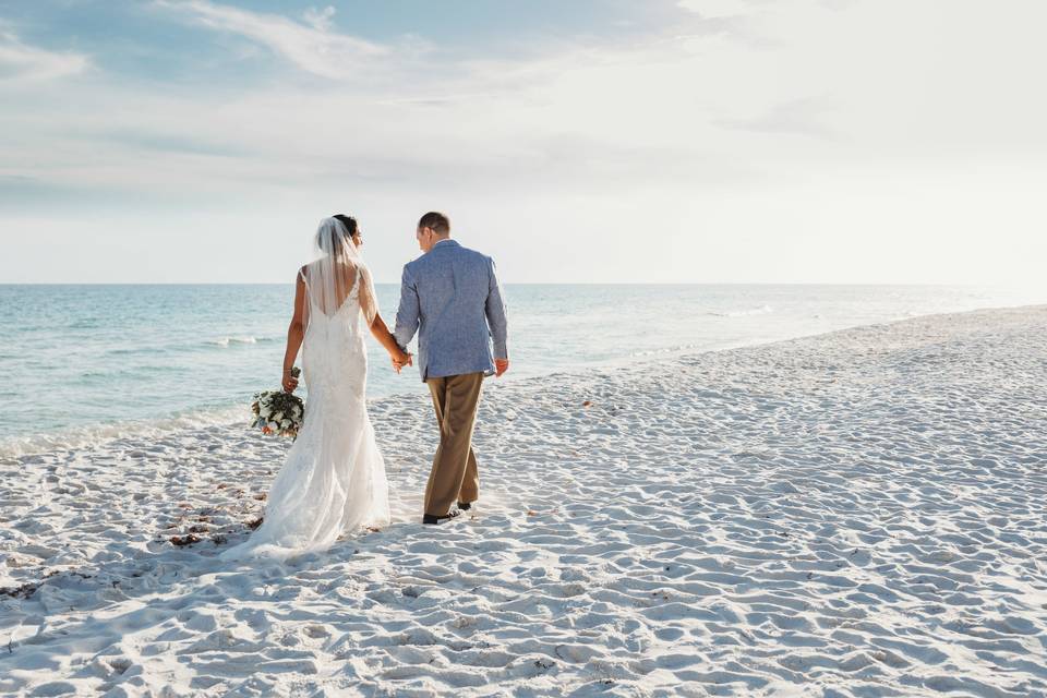 Bride & groom walking on beach