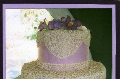 Small 2 tier Buttercream cake with Light and dark Lilac colored Gumpaste flowers.