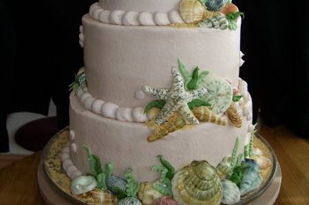This is a tan buttercream stacked Wedding Cake.  It has hand painted white chocolate shells on top and sides.