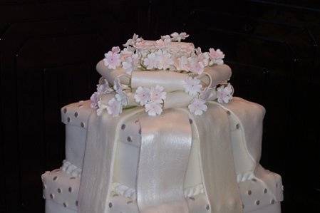 White Pearl Fondant Stacked Boxes.  Fondant Bow with Gumpaste flowers on top.