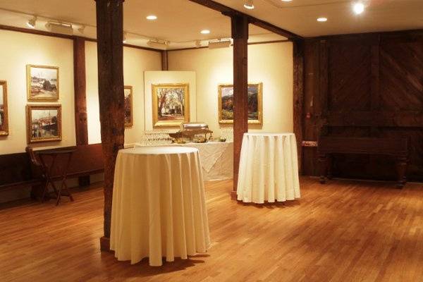 For this wedding, the bride decided to convert the Maddocks Gallery into an area for food stations, standing tables and cocktails. One food station is pictured in the corner of this photograph. Not pictured is a large bar set-up to the right of the sliding barn door, and another food station is set up in the corner to the far left of the room. Elegant wooden benches surround the perimeter of the room, a perfect addition to the rustic elegance of the Maddocks Gallery.