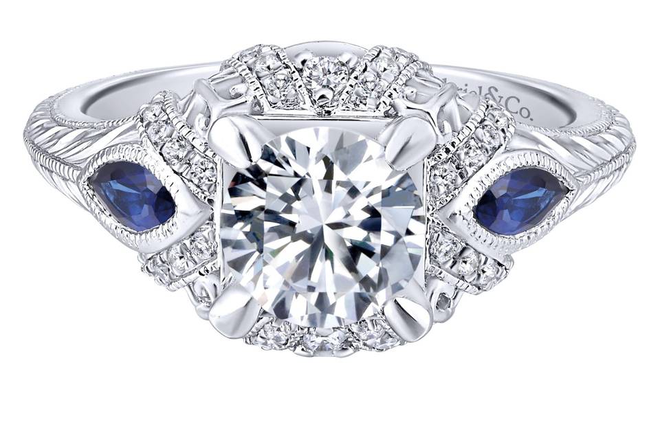 ER12583R4W44SA	<br>	Marquis cut sapphire side stones add a rich pop of color to this sumptuous engagement ring. An exceptional halo of pave diamond ribbons and a carved white gold band complete this elevated style.