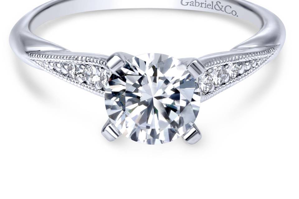 ER11750R4W44JJ	Tapered strings of graduated diamonds adorn the shoulders of a slim white gold band in this elegant diamond engagement ring.