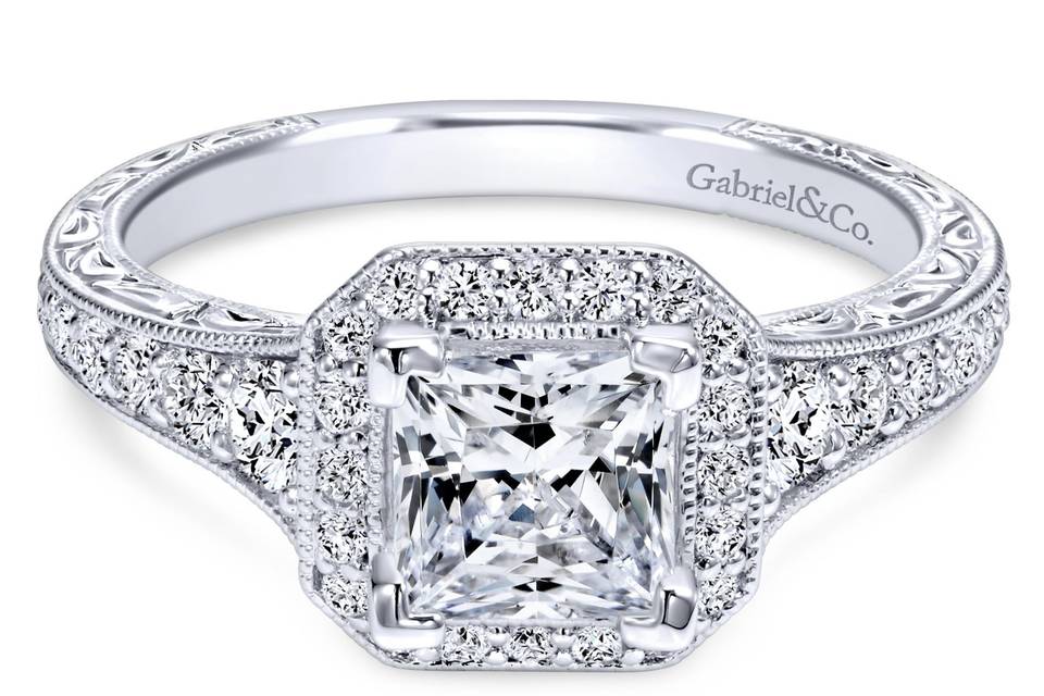 ER11793S4W44JJ	Glitzy scroll work on the band that holds the glamourous diamond filled channels come together to meet the spectacular princess cut halo.