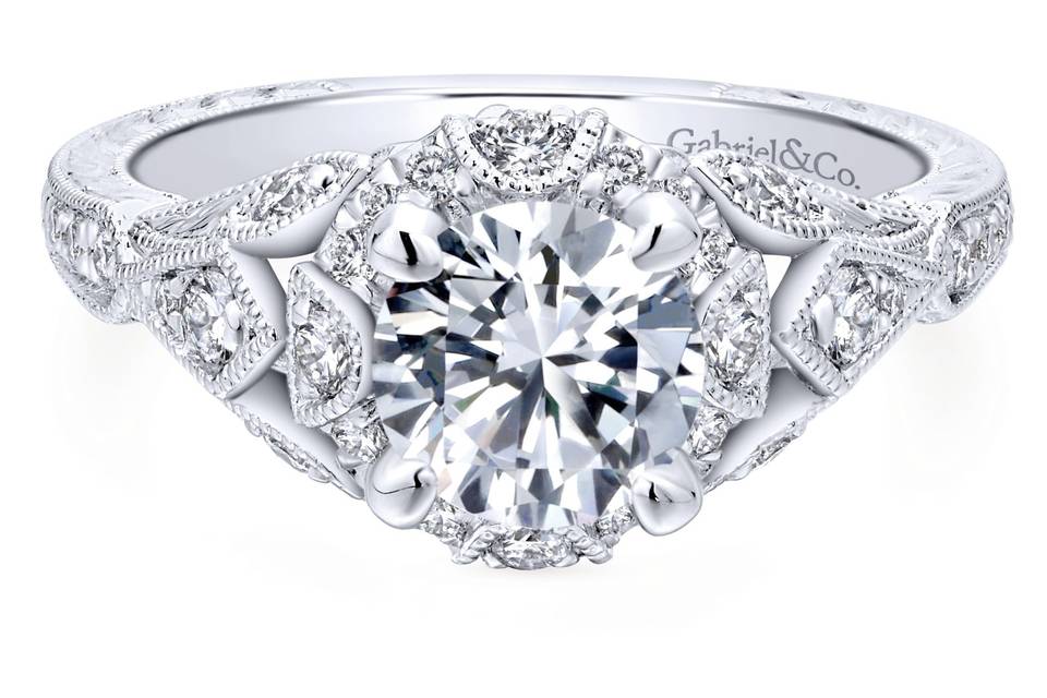 ER12579R4W44JJ	Milgrain accents within the diamond halo and around petal-shaped diamond clusters on the shoulders of the band add an heirloom feel to this stylish white gold engagement ring.
