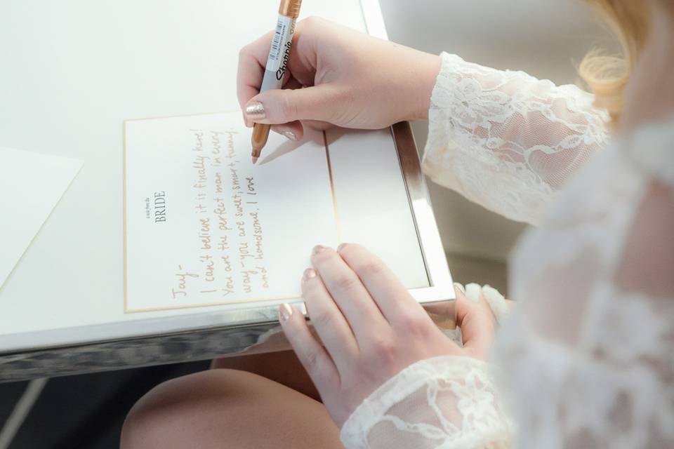 Bride writing love letter to groom before wedding at Arlington Hall, in Dallas , Texas.