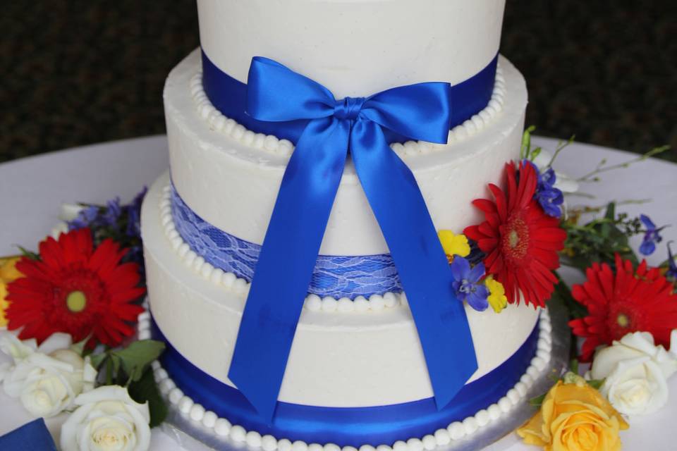 Classic Buttercream Layers, With Blue Satin Ribbon, And Fresh Flowers.