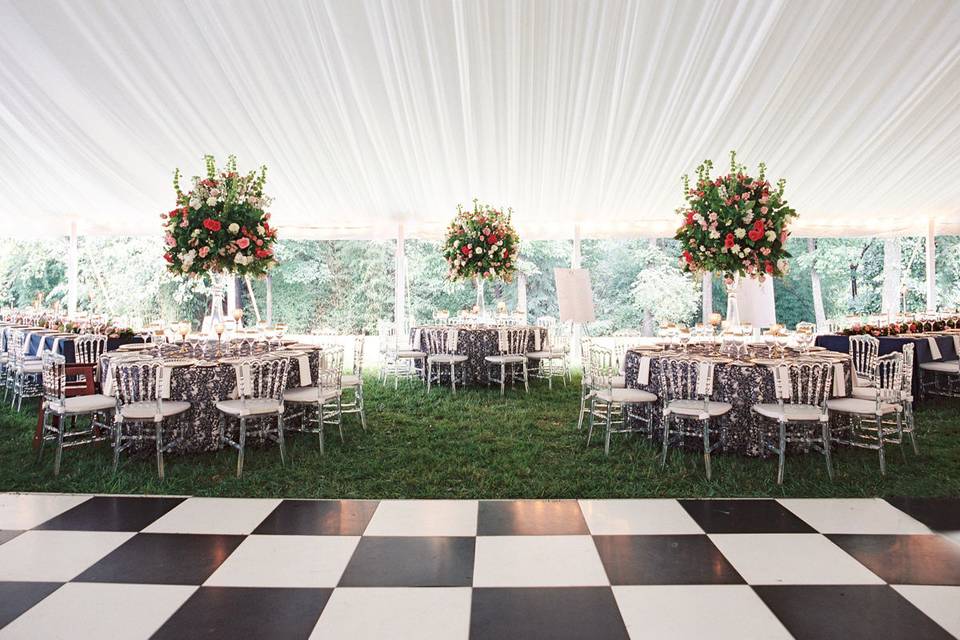 Black and white dance floor pops with the handpleated white fabric lining this wedding tent.