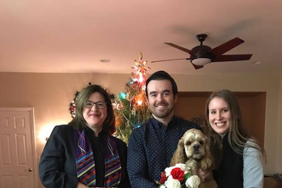 Newlyweds and their dog with the officiant