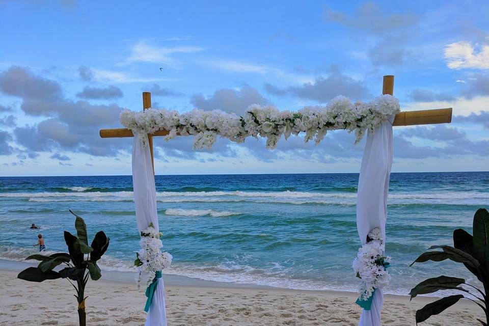 White drapes on 2 post arbor with turquoise sashes with white flowers & flower topper