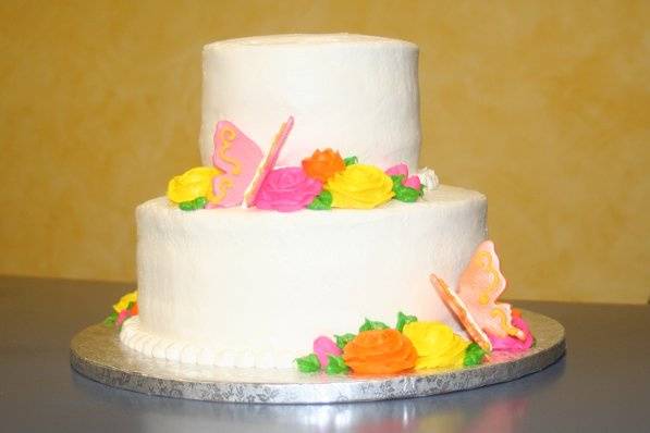 Two tier cake frosted in buttercream with fondant butterflies