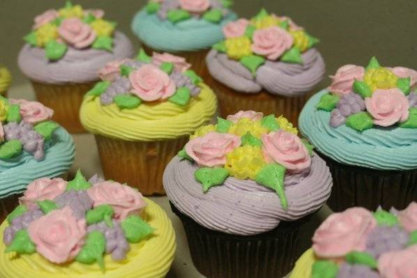Cupcakes with buttercream frosting and piped flowers in pastel colors