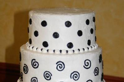 Three tier black and white cake frosted in buttercream