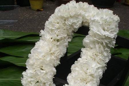 White double carnation lei is worn by the brides mom or future mother-in-law during the wedding ceremony.