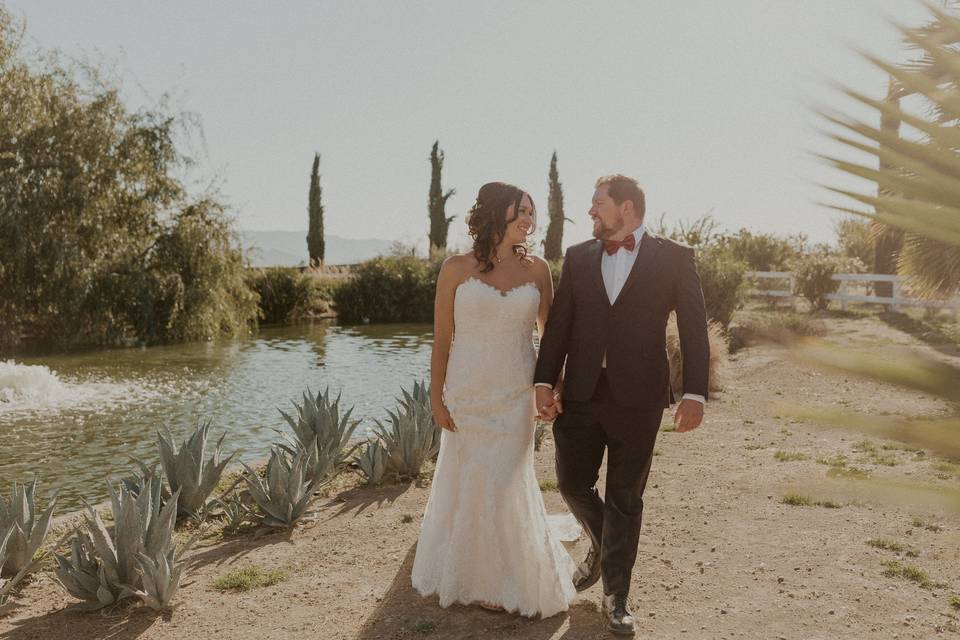 Couple walking past pond.