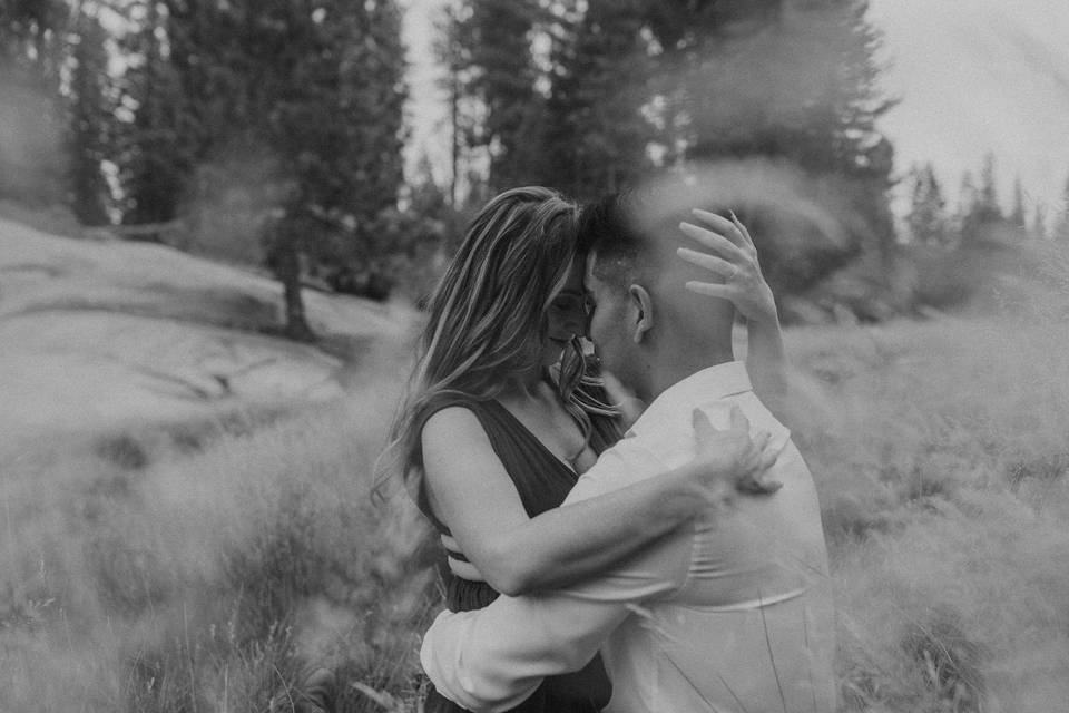 Couple cuddled up in field.