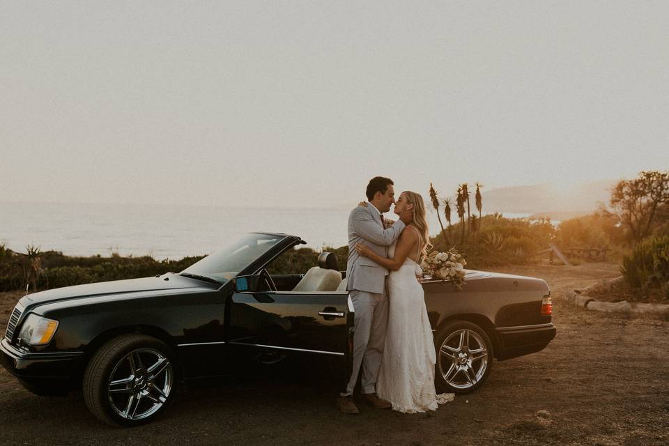 Couple with car at sunset.