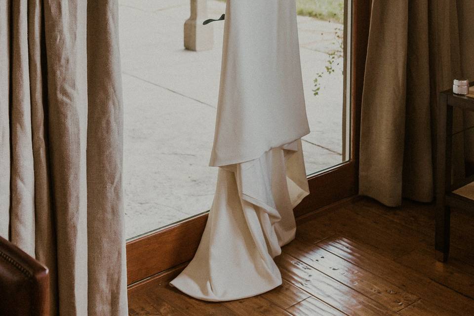 Wedding dress hanging in door.
