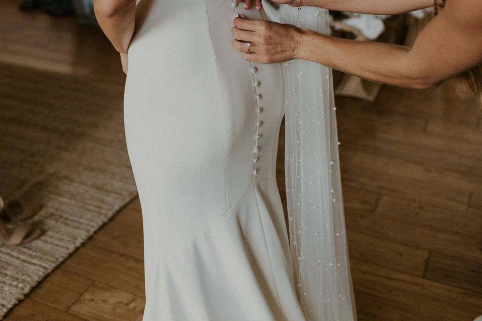 Buttoning up wedding dress.