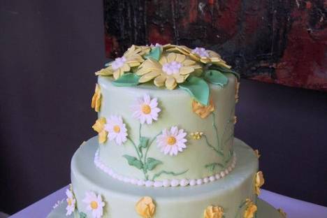Fondant cake covered with lilac swirl pattern, topped with edible sugar flowers
