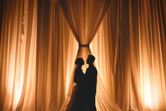 22' draped backdrop, floor to ceiling, at Ruthe Jackson Center.  Candlelight up lighting. Floral and cake pin spotting rounds out a breathtaking ballroom.
