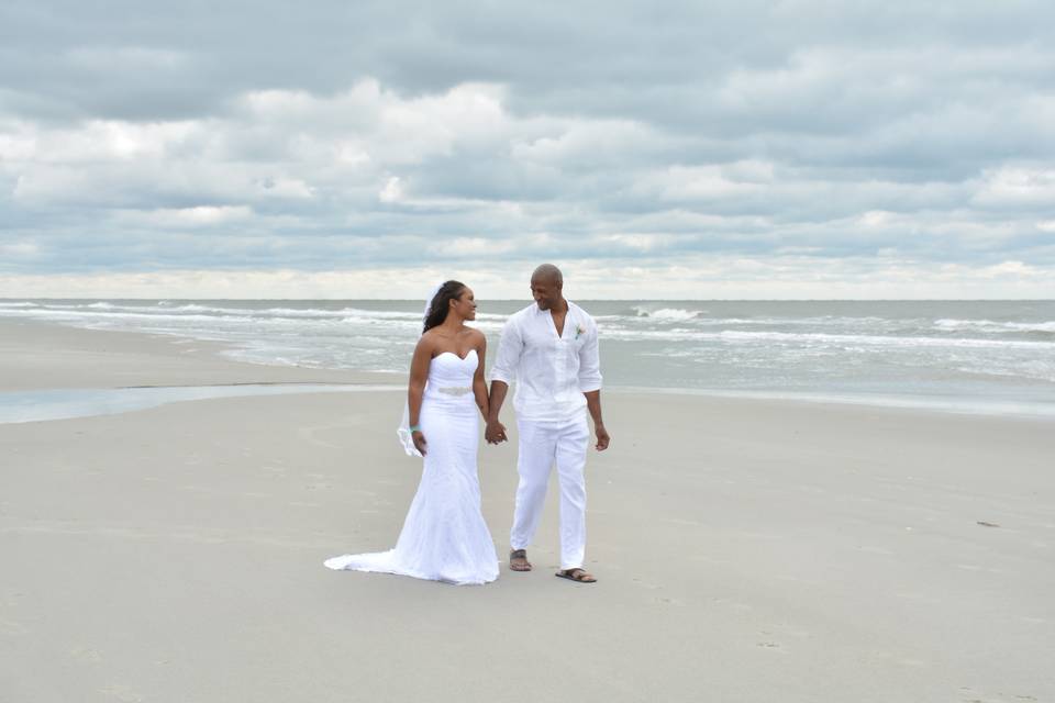 Newlyweds walking along the beach