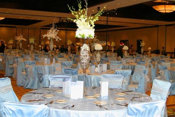 Beautiful white orchids and winter flowers and branches add drama to the sparkling linens for this beautiful winter wonderland theme for 500