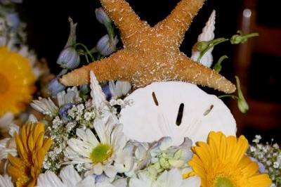 fun starfish and sand dollars add a festive spirit to the beach side ceremony , detail of chuppah toppers