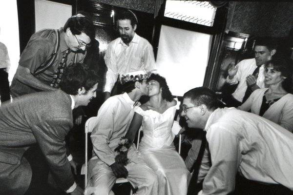 About to be raised for the hora a happy couple at a  progressive Jewish wedding celebration.