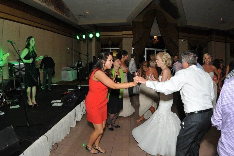 Couple and guests dancing over the music