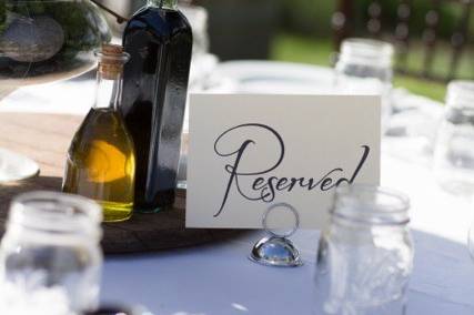 The tables were set with Reserved signs by A Perfect Day, Mason jar water glasses, tables dressed for bread with oil and vinegar, Orchid centerpieces were placed upon wine barrel tops.