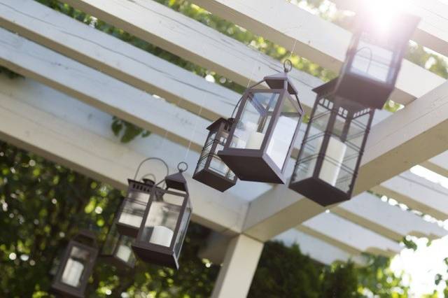 Dark Brown Wood Chivari chairs, ivory lanterns, bistro lights, wine barrel tops with orchid centerpieces and ivory linen.