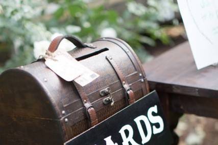 Dark brown trunks stacked upon a wine barrel made a picturesque card recepticle.