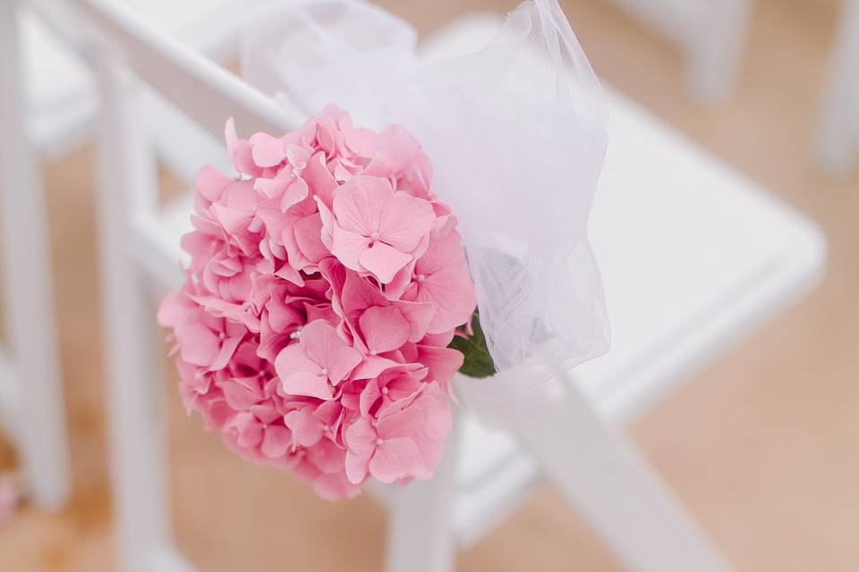 Close up the rose adorned arch with crystal chandelier. Shabby chic wreaths and garlands added to the decor