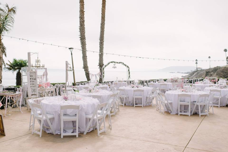 Reception table linens were ruffled cream, mismatched large white centerpieces held candles and bud vases with pale pink roses.