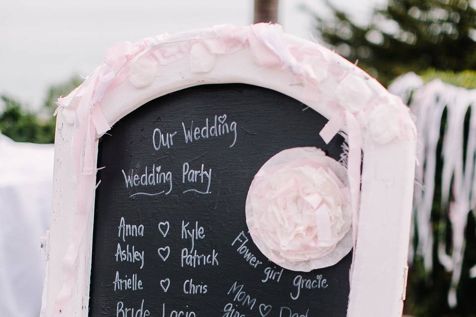 Wedding Program was written on a shabby chic chalkboard at the entrance to the Ceremony