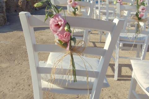 Chez Gerdi patio Ceremony site with the Baleric Sea for a most perfect backdrop. White wood chairs were decorated with flowers.