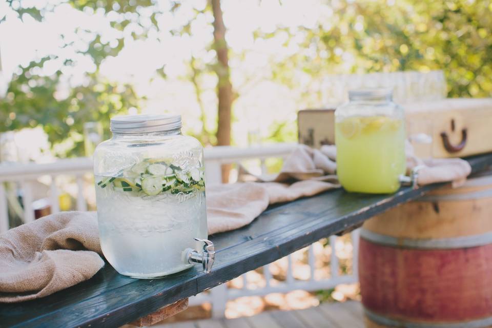 The non-alcoholic station at cocktail hour was made up of a wood plank between two wine barrels decorated with burlap, one of A Perfect Day's vintage trunks and mason jar glassware.