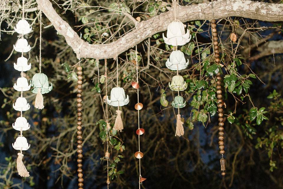 The Sweetheart table had glass floral garlands hanging from the branch of an oak tree that was directly above their vintage wood table. Fun 70's-esque planters in gold and bronze and amber glass bowls held succulents and varying floral. Floral design by Adornments. Photography by Jamie and Chase Photography.