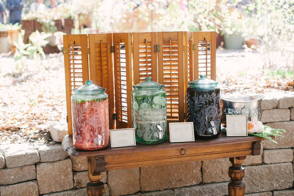 Non alcoholic beverages were displayed on a vintage table with wood shutters adding some ambiance behind the dispensers. Photo courtesy of Jamie and Chase.