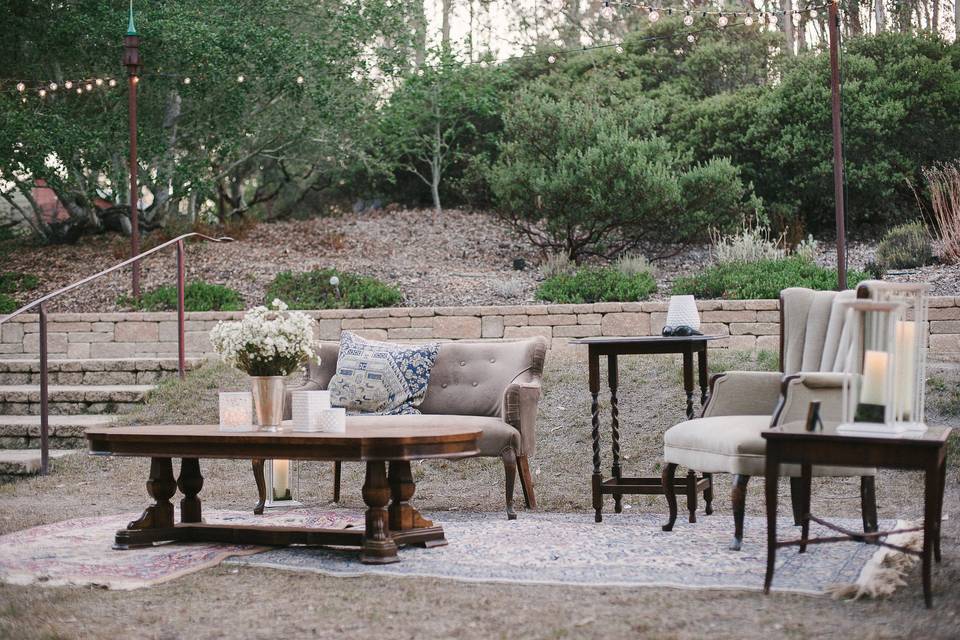 Cocktail tables were on the grassy area near the bar, with sand colored linens, tea lights and succulents in bronze goblets. Photo by Jamie and Chase photography.