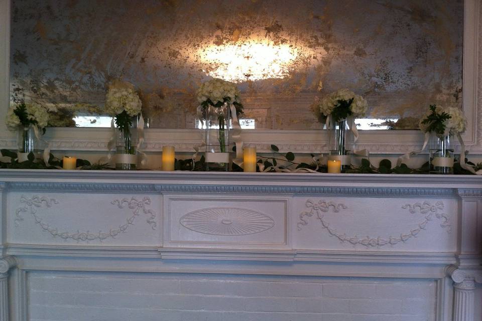 The mantle in The Mansion at Noble Lane was decorated with five vases of Hydrangeas and ivy, adorned with ivory ribbons.